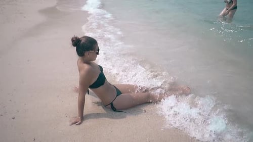 Girl in Sunglasses Takes Sunbath and Woman Walks to Bank