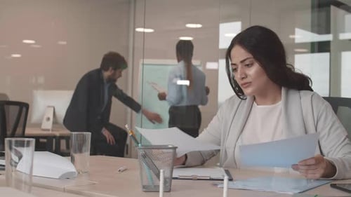 Woman Reviews Documents in Modern Office