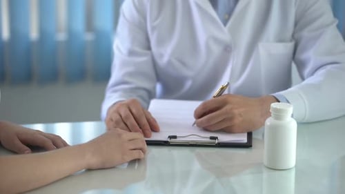 Doctor Writing Prescription and Taking Pills