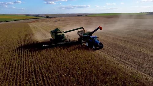 Harvester Unloading Crops Into Tractor, Rural Landscape