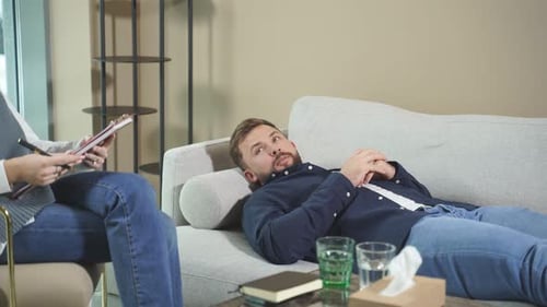 Man Talking to Therapist on Couch in Office