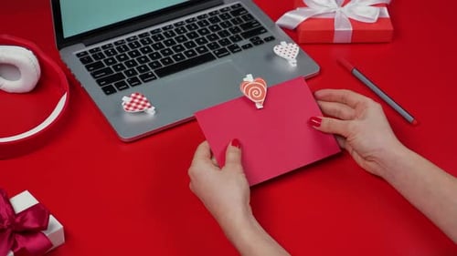 Hands Preparing Valentine's Card in Pink Envelope