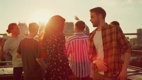 Friends Dancing at a Rooftop Party at Sunset
