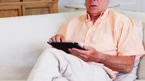 Senior Man Relaxing at Home With Tablet