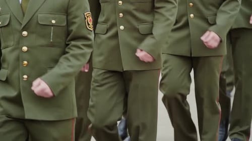 Military Men in Green Uniforms March Across Parade Ground