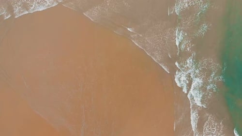 Aerial View of Sea Waves Break on Yellow Sand Beach