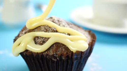 Drizzling White Icing on Decadent Chocolate Cupcake