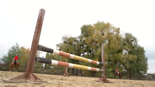 Horses Jumping Hurdles in Outdoor Arena