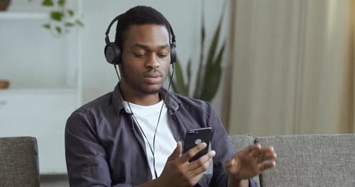 Young Adult Listening Music on Smartphone Indoors