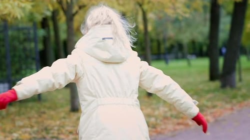 Niña divirtiéndose jugando al aire libre en otoño en Orange Park