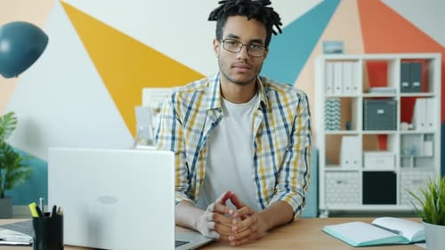 Slow Motion Portrait of Good-looking Afro-American Man at Desk in Office Room