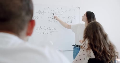 Teacher Writes Math Formulas on Blackboard in School Classroom.