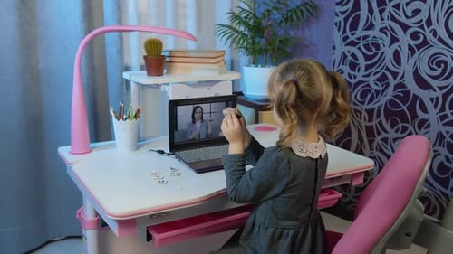 Child Using Laptop for Online Education at Desk