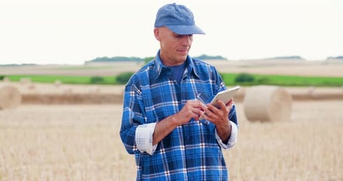 Farmer Using Digital Tablet While Examining Field