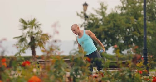 Young Male Athlete Does Exercise on the Street Warm Up