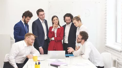 Business Team Collaborating Around Laptop in Modern Office