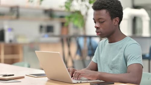 Young Adult Working on Laptop in Office