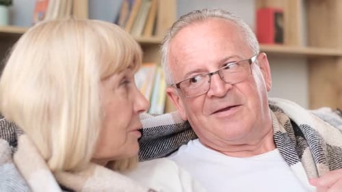 Loving Senior Couple Talking Together Indoors