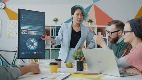 Asian Girl Making Presentation for Multi-ethnic Team of Designers in Office