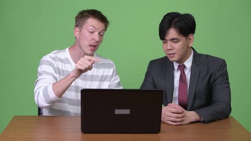 Two Men Show Disagreement with Thumbs Down