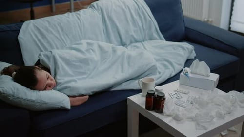 Sick Woman Sleeping on Couch at Home