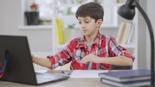 Boy Attends Online Class at Home with Laptop