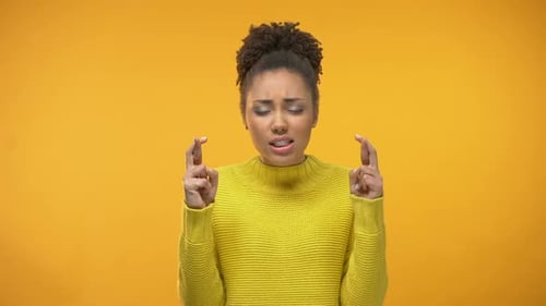 Black Girl Crossing Fingers for Good Luck in Expectation of Winning Lottery