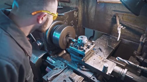 Man Operating Lathe Machine in Industrial Workshop