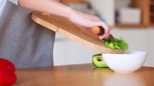 Woman Chopping Peppers in Bright Kitchen