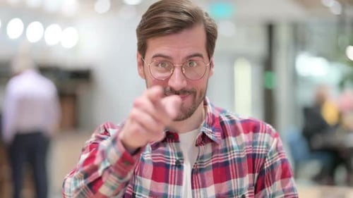 Man Points at the Camera With a Smile