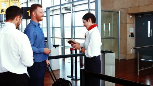 Female airport staff checking passport of commuters