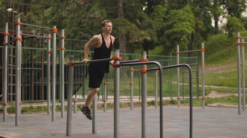 Man Doing Parallel Bar Dips at Outdoor Gym