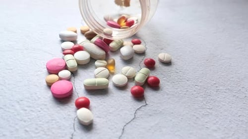 Close Up of Colorful Pills Spilling on White Background