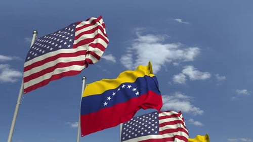 United States and Venezuela Flags Waving Against Blue Sky