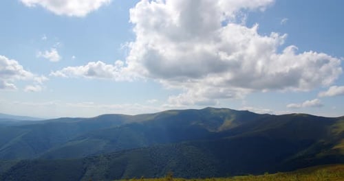 Rolling Mountains with Blue Sky and White Clouds