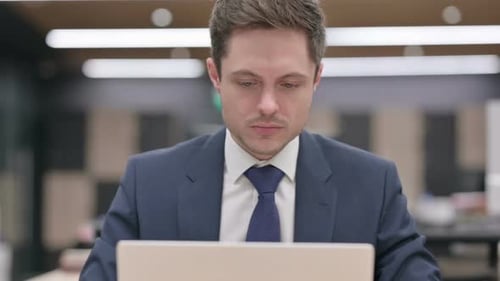 Man Working on Laptop in Office