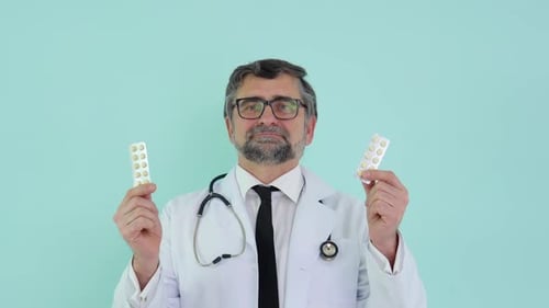 Doctor Holding Packs of Pills in Medical Setting