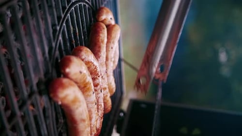 Fleischwürste werden auf dem Grill des Street Grill gebraten