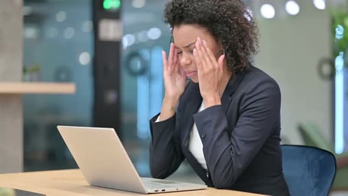 Woman Works on Laptop, Touches Temples