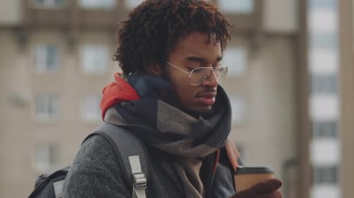 Black Man Drinking Coffee on Cold Day Outdoors
