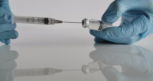 Hands Filling Syringe with COVID-19 Vaccine