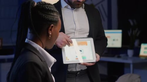 Business Team Discussing Charts on Tablet
