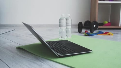Home Fitness Setup with Laptop and Exercise Equipment