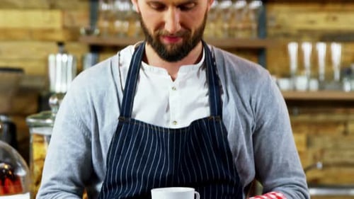 Smiling Man Holds Coffee Cup in Cafe