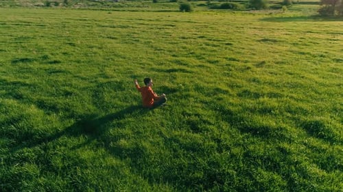 Hombre de yoga deportivo de vuelo radial a baja altitud en Perfect Green Grass
