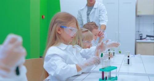 Teacher and Students Doing Science Experiment in School Classroom