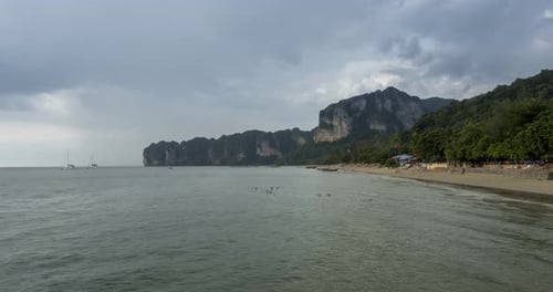 Zeitraffer der Regenwolken über Strand und Meereslandschaft mit Booten