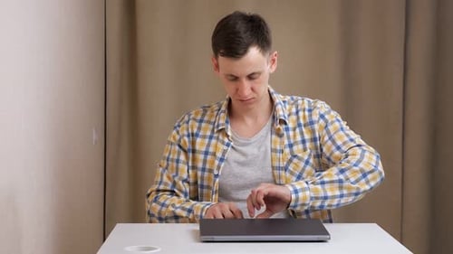 Young Adult Opens Laptop and Begins Typing