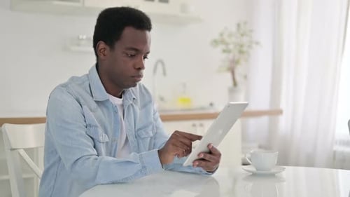 Young Adult Using Tablet in Bright Kitchen