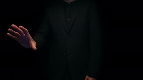 Person in a Suit Moves Hand in Studio